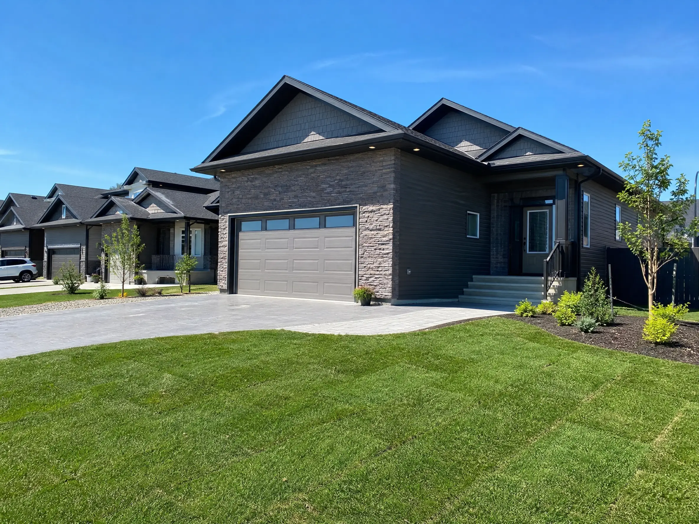 A landscaped new-build yard with fresh sod in Warman, SK